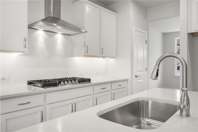 373 Riverwood Pass, Dallas, GA 30157 - kitchen with wall chimney exhaust hood, stainless steel gas cooktop, a sink, white cabinets, and decorative backsplash