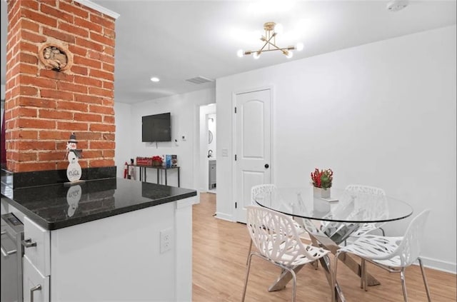 kitchen featuring a notable chandelier, dark stone counters, and light wood-type flooring