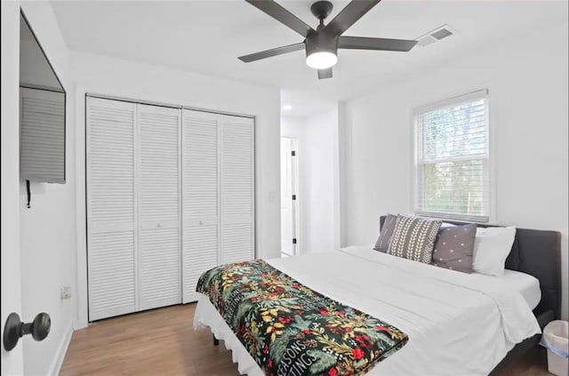 bedroom with hardwood / wood-style floors, a closet, and ceiling fan