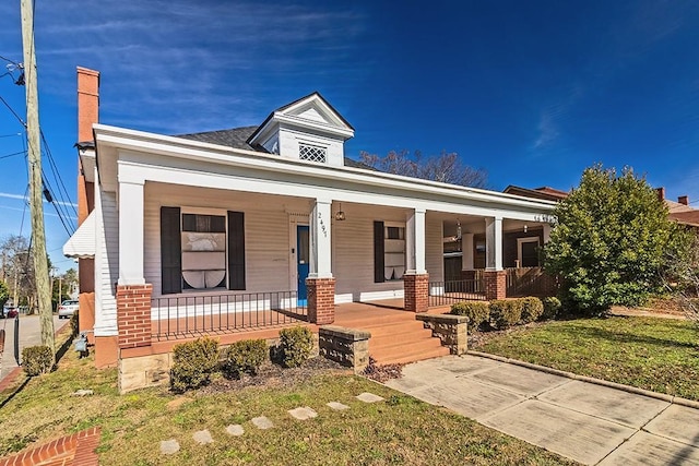 view of front of home with a porch and a front yard