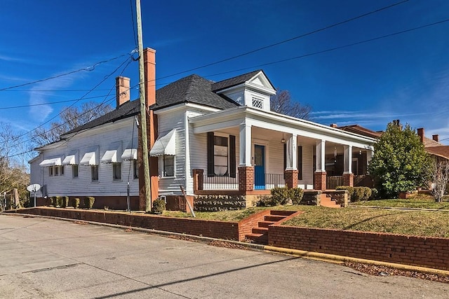 view of front of house featuring covered porch and a front yard