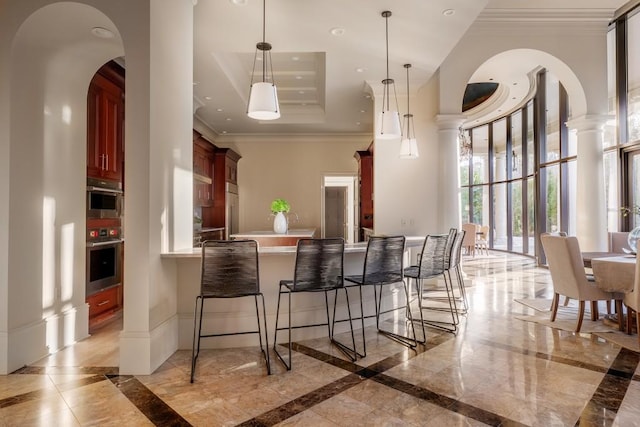 bar with appliances with stainless steel finishes, decorative columns, ornamental molding, a high ceiling, and hanging light fixtures