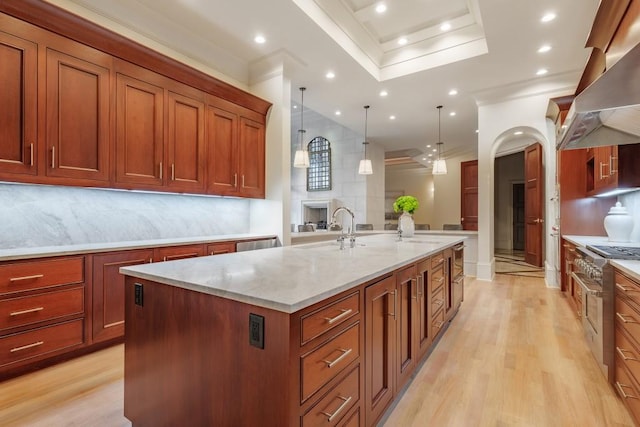 kitchen featuring decorative backsplash, light stone counters, ventilation hood, a spacious island, and pendant lighting