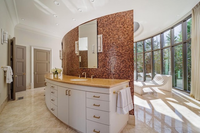 bathroom with vanity, a wall of windows, ornamental molding, and backsplash