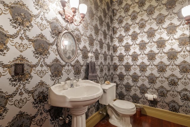 bathroom with wood-type flooring, toilet, and a notable chandelier