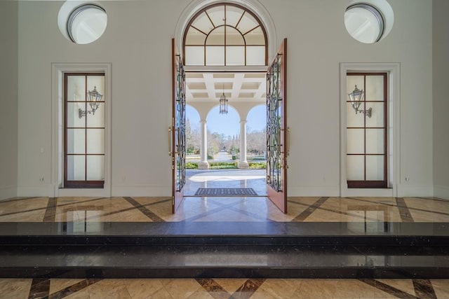 entrance foyer featuring coffered ceiling, beam ceiling, and french doors