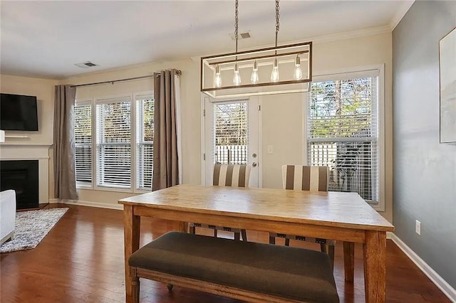 dining room featuring visible vents, a healthy amount of sunlight, dark wood-style flooring, and baseboards