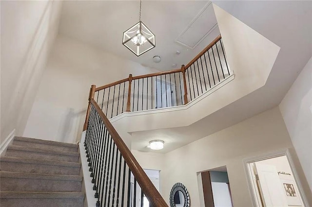 stairway featuring a towering ceiling