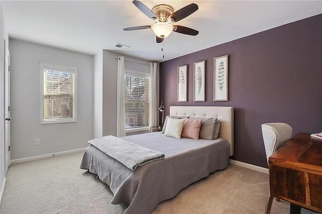 bedroom featuring light carpet, visible vents, a ceiling fan, and baseboards