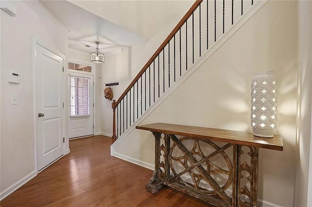 entryway with stairs, wood finished floors, and baseboards