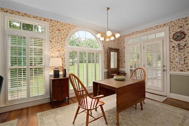 416 Mcdaniel St, Monroe, GA 30655 - dining area with wallpapered walls, crown molding, wood finished floors, healthy amount of natural light, and a chandelier