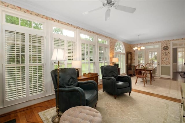 416 Mcdaniel St, Monroe, GA 30655 - sitting room featuring crown molding, a chandelier, wood finished floors, wallpapered walls, and a wainscoted wall
