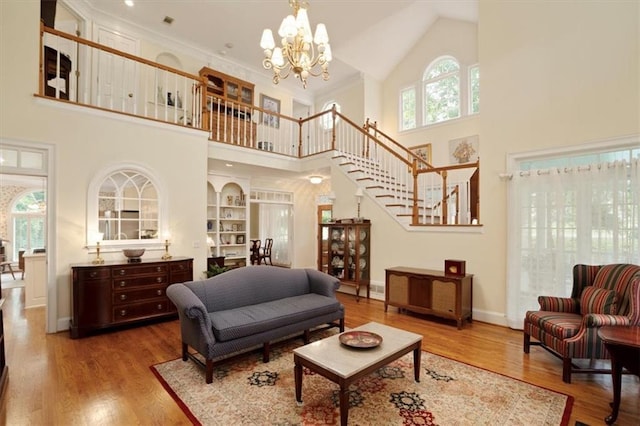 416 Mcdaniel St, Monroe, GA 30655 - living area featuring a high ceiling, stairs, a chandelier, wood finished floors, and baseboards