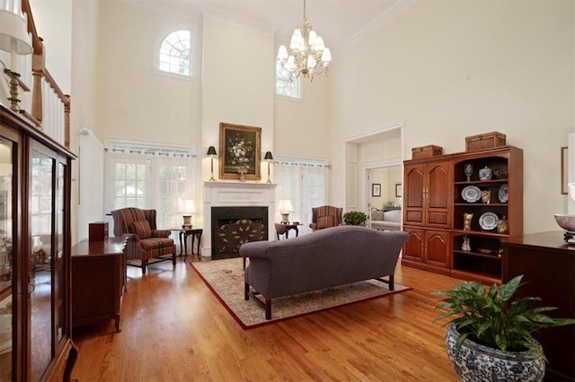 416 Mcdaniel St, Monroe, GA 30655 - living area featuring a towering ceiling, a fireplace, ornamental molding, wood finished floors, and healthy amount of natural light