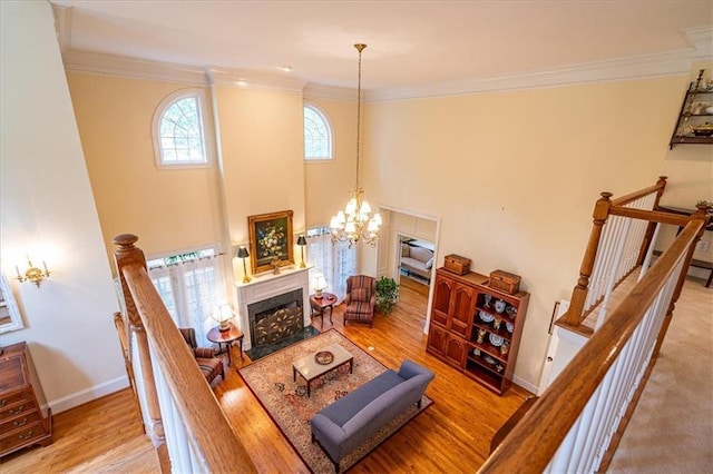 416 Mcdaniel St, Monroe, GA 30655 - living room featuring wood finished floors, a fireplace with flush hearth, ornamental molding, baseboards, and a chandelier