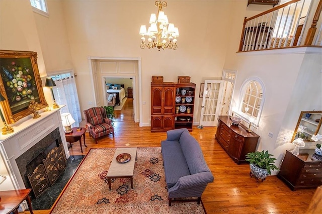 416 Mcdaniel St, Monroe, GA 30655 - living area with a high ceiling, wood finished floors, a chandelier, a fireplace, and baseboards
