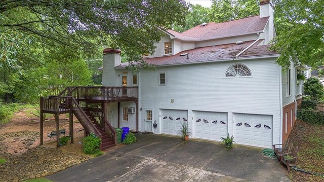 416 Mcdaniel St, Monroe, GA 30655 - rear view of property with a chimney, a garage, concrete driveway, and stairs
