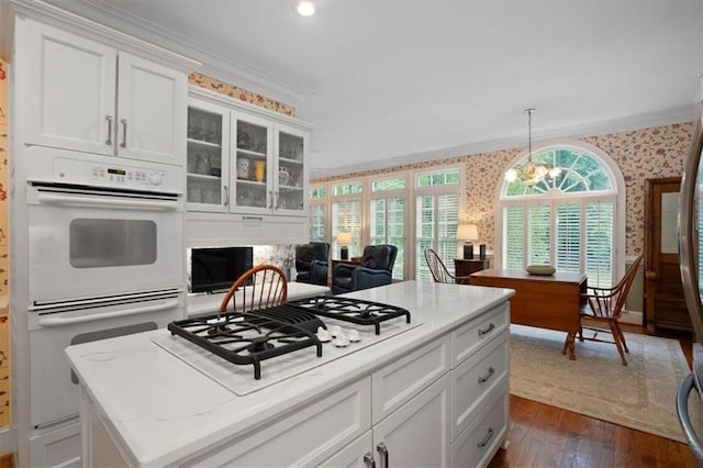 416 Mcdaniel St, Monroe, GA 30655 - kitchen featuring wallpapered walls, white appliances, crown molding, dark wood-style floors, and white cabinetry