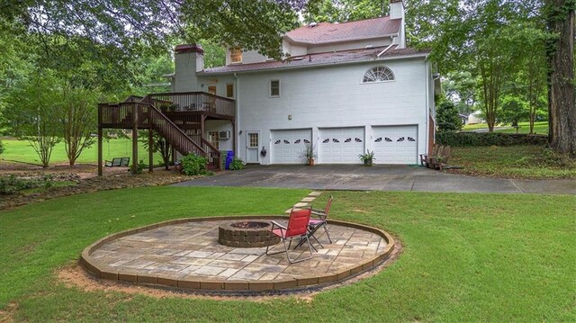 416 Mcdaniel St, Monroe, GA 30655 - back of property with a chimney, a garage, a fire pit, stairs, and a deck