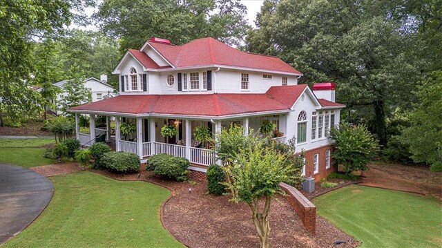 416 Mcdaniel St, Monroe, GA 30655 - country-style home featuring a front yard, covered porch, and view of wooded area