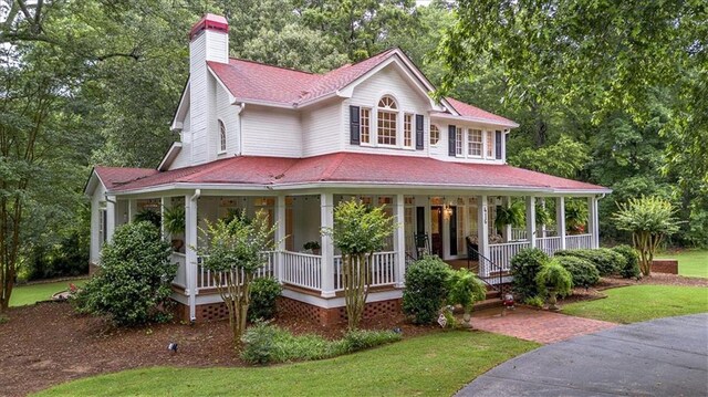 416 Mcdaniel St, Monroe, GA 30655 - farmhouse with covered porch, a chimney, a front yard, and a shingled roof