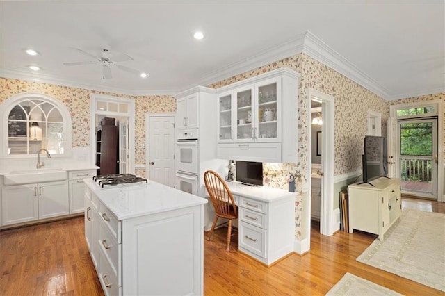 416 Mcdaniel St, Monroe, GA 30655 - kitchen featuring wallpapered walls, a sink, ornamental molding, stainless steel gas cooktop, and white cabinets