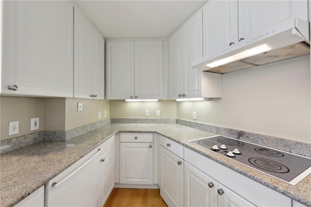kitchen featuring under cabinet range hood, electric cooktop, white cabinetry, light wood finished floors, and light stone countertops