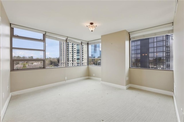 carpeted spare room with baseboards and healthy amount of natural light