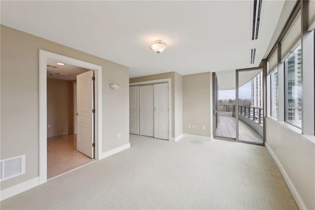 unfurnished bedroom featuring access to outside, carpet flooring, a closet, and baseboards
