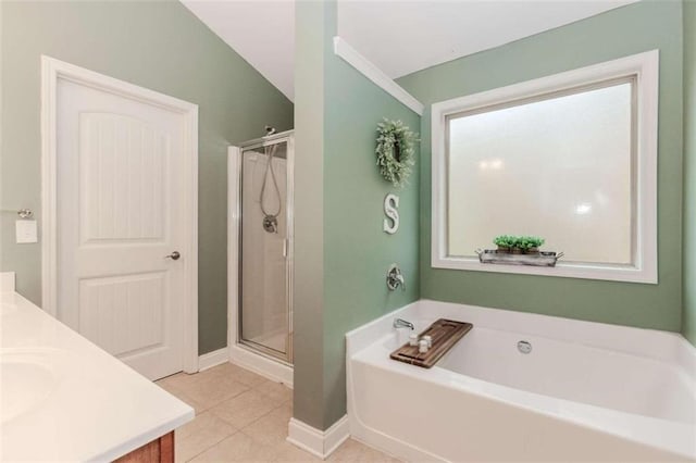 bathroom with tile patterned floors, vanity, separate shower and tub, and lofted ceiling