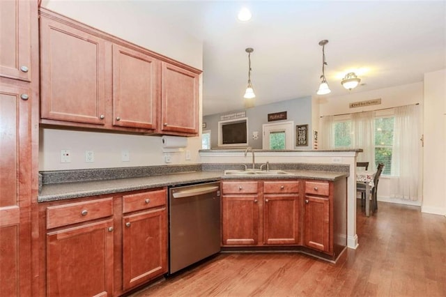 kitchen with kitchen peninsula, sink, wood-type flooring, dishwasher, and hanging light fixtures