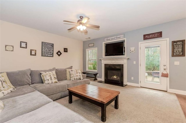 carpeted living room with ceiling fan and a healthy amount of sunlight