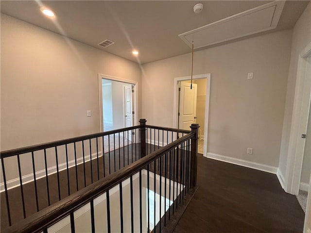 hall with attic access, an upstairs landing, dark wood-style floors, recessed lighting, and baseboards