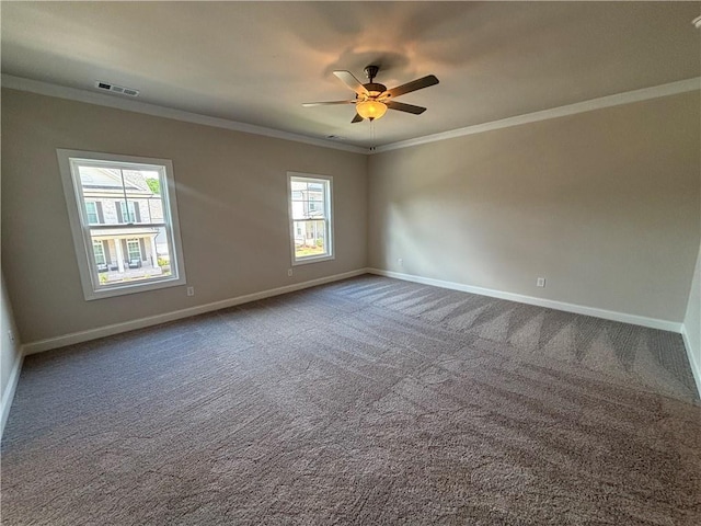 carpeted spare room featuring crown molding, baseboards, and a ceiling fan