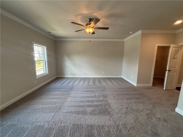 unfurnished room with baseboards, dark colored carpet, a ceiling fan, and crown molding