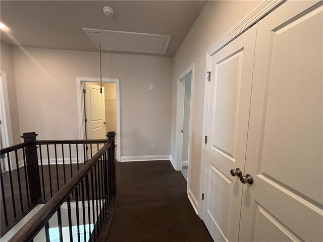 hallway with attic access, an upstairs landing, and baseboards