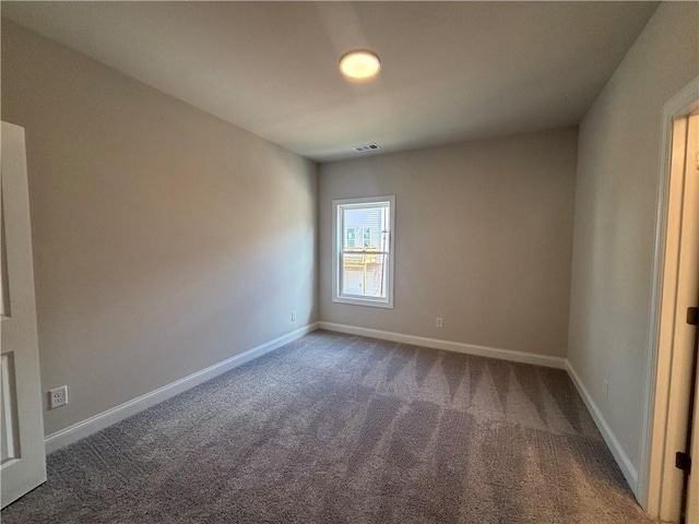 empty room featuring carpet floors and baseboards