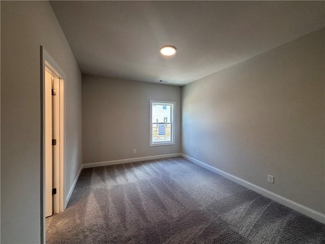 carpeted empty room featuring baseboards