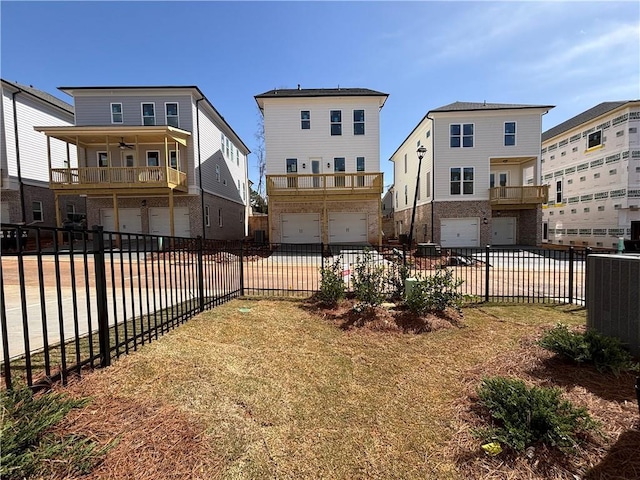 view of yard with a garage, ceiling fan, central air condition unit, and a balcony