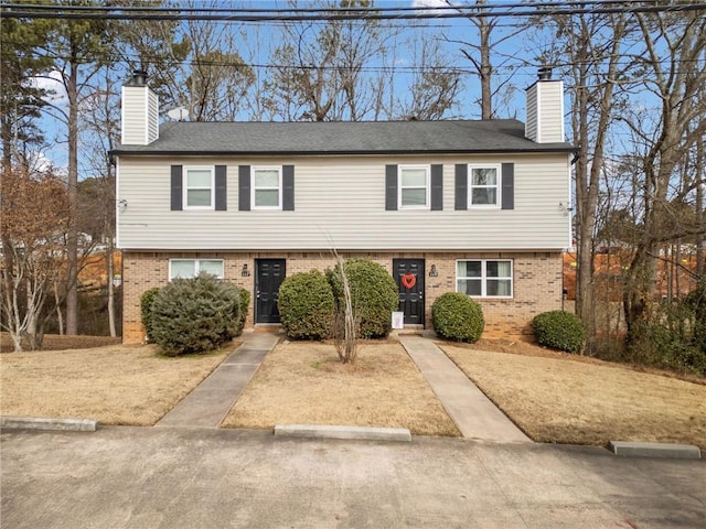 view of front of house with brick siding and a chimney