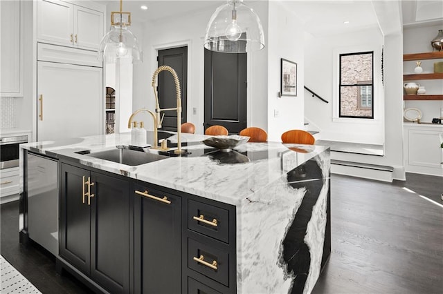 kitchen featuring dark cabinets, dark wood-type flooring, a kitchen island with sink, and white cabinets