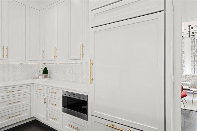 kitchen with decorative backsplash, light countertops, and white cabinets