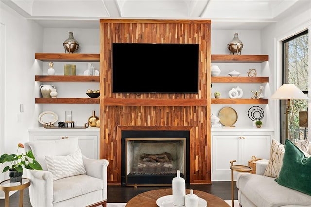 living area with built in features, a fireplace, and dark wood-style flooring