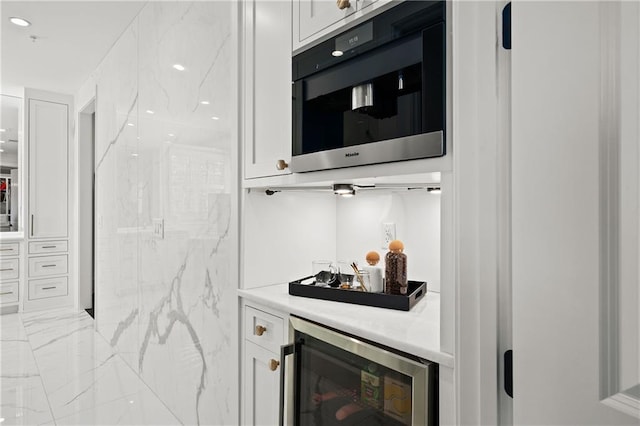 kitchen featuring white cabinetry, light countertops, glass insert cabinets, and beverage cooler