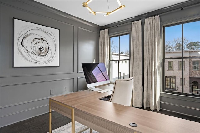 office space featuring a decorative wall, plenty of natural light, and wood finished floors