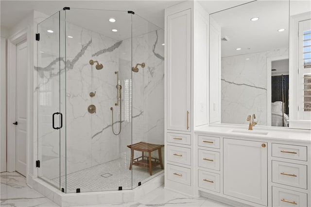 bathroom featuring a marble finish shower, recessed lighting, marble finish floor, and vanity