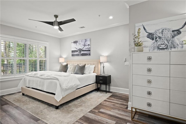 bedroom featuring visible vents, crown molding, baseboards, a ceiling fan, and dark wood-style flooring