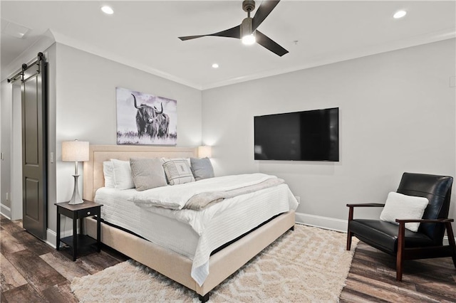 bedroom with a barn door, baseboards, recessed lighting, wood finished floors, and crown molding
