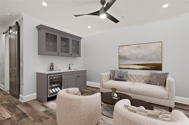 living area featuring wet bar, beverage cooler, a barn door, recessed lighting, and baseboards