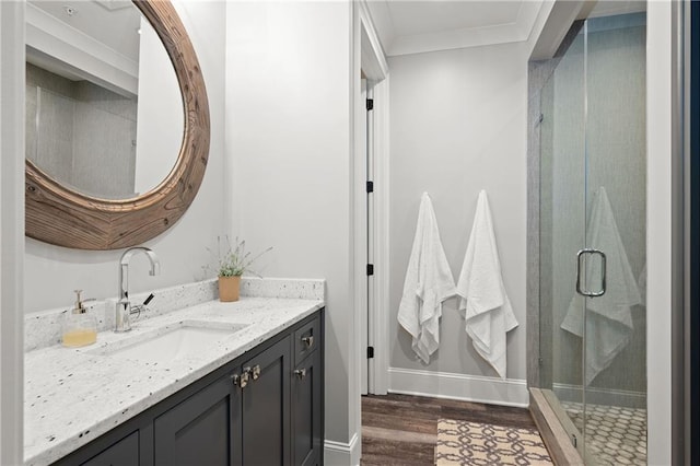 full bathroom with wood finished floors, a shower stall, vanity, and crown molding